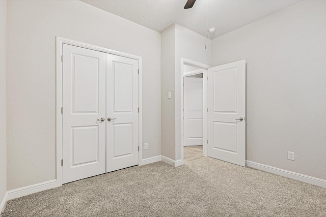 unfurnished bedroom with ceiling fan, a closet, and light carpet