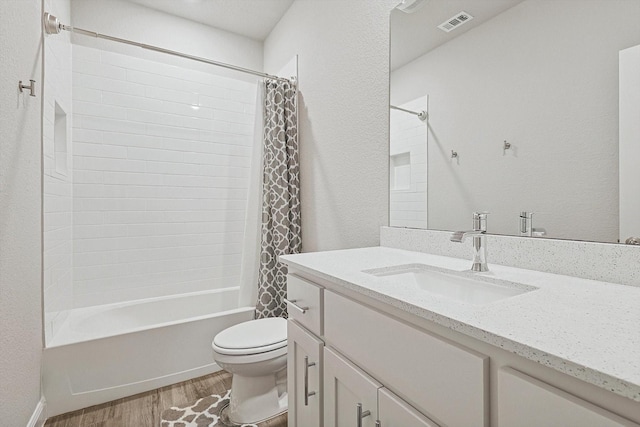 full bathroom featuring hardwood / wood-style floors, vanity, shower / bath combination with curtain, and toilet