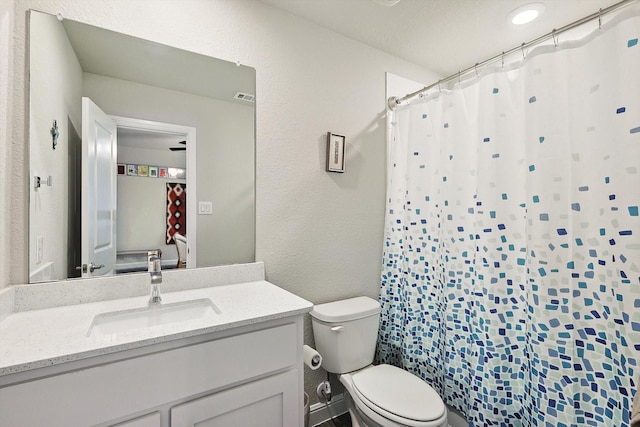 bathroom featuring vanity, toilet, and curtained shower