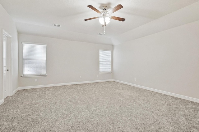 carpeted spare room featuring ceiling fan and lofted ceiling