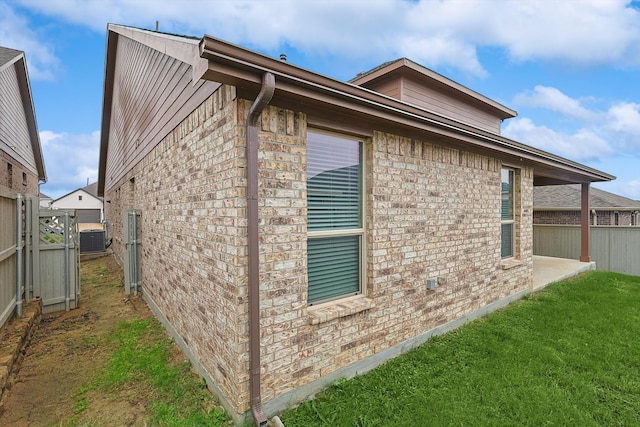 view of property exterior with a yard and central air condition unit