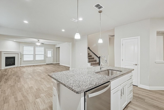 kitchen featuring ceiling fan, dishwasher, sink, hanging light fixtures, and white cabinets