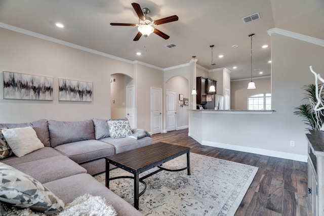 living room featuring dark hardwood / wood-style floors, ceiling fan, and ornamental molding