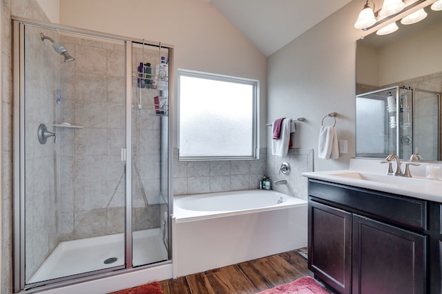 bathroom with hardwood / wood-style floors, vanity, lofted ceiling, and plus walk in shower