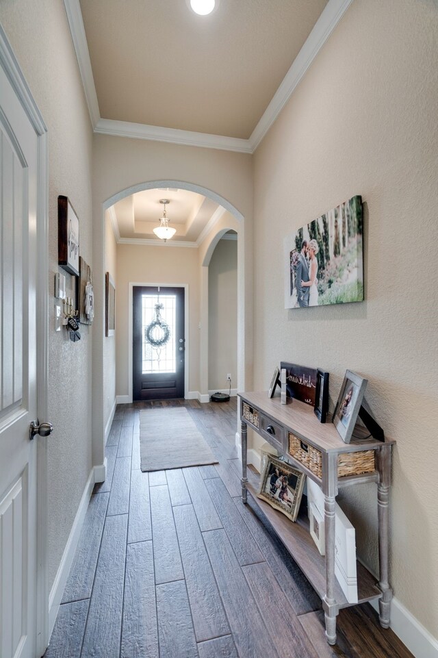 entryway with hardwood / wood-style flooring and crown molding