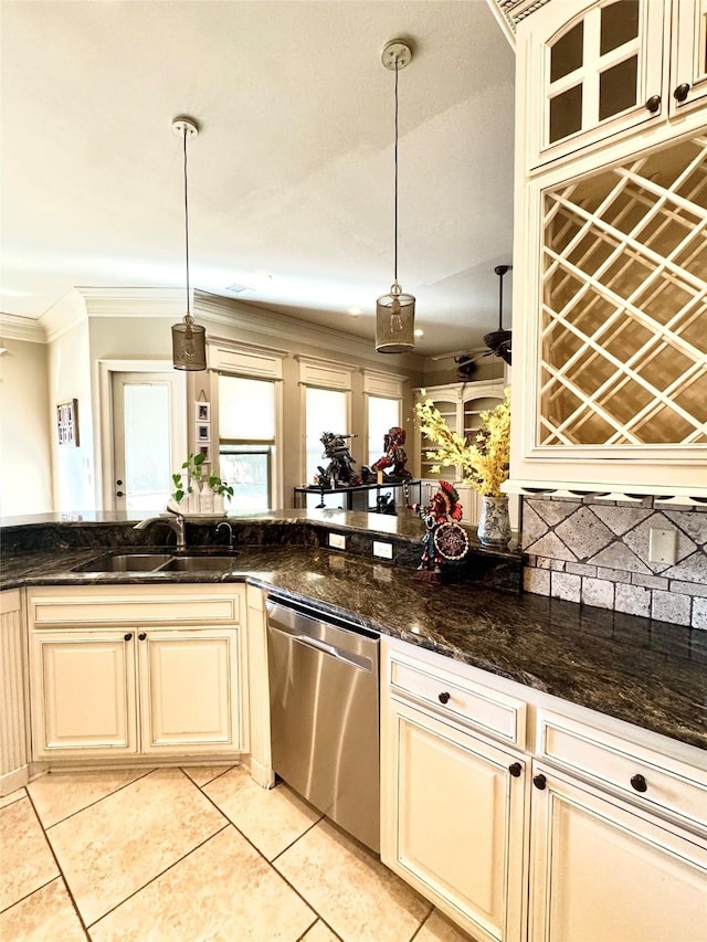 kitchen featuring light tile patterned floors, dishwasher, ornamental molding, cream cabinetry, and a sink