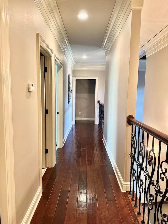 hallway with ornamental molding, wood-type flooring, and baseboards