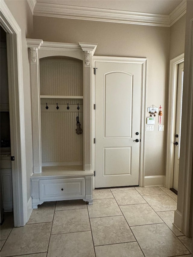 mudroom featuring crown molding, baseboards, and light tile patterned floors