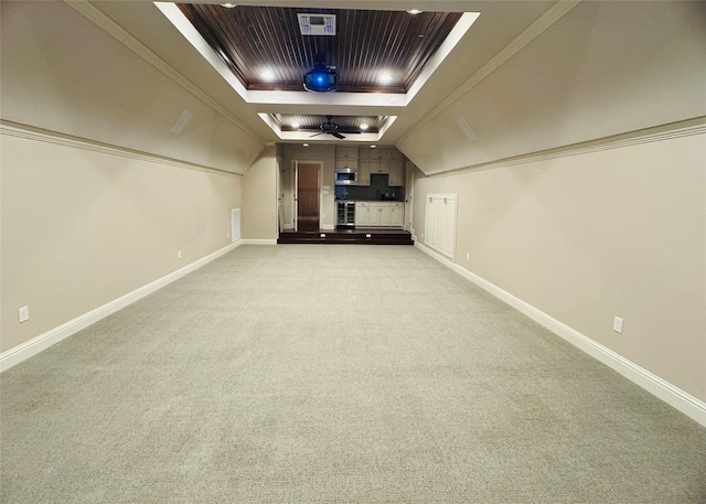 cinema room featuring a raised ceiling, light colored carpet, and baseboards