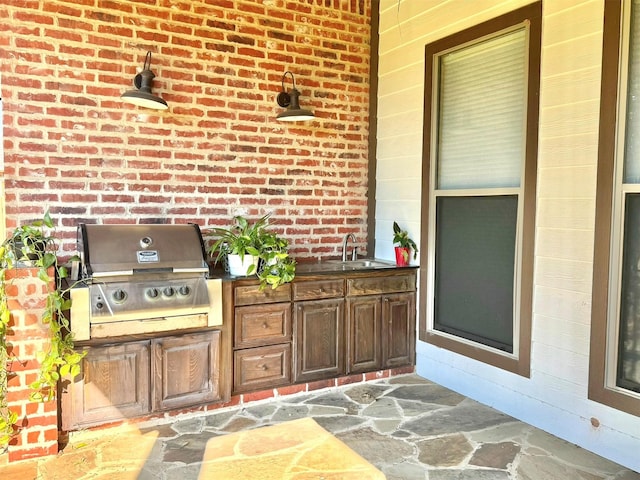 view of patio featuring exterior kitchen, a sink, and area for grilling