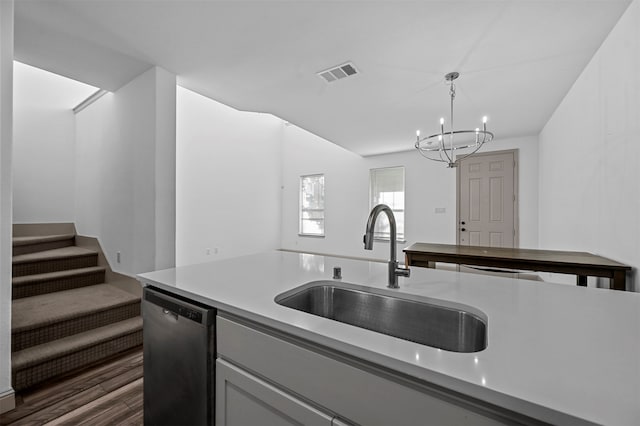 kitchen featuring sink, decorative light fixtures, stainless steel dishwasher, dark wood-type flooring, and a chandelier