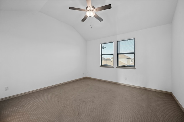 carpeted spare room with ceiling fan and vaulted ceiling