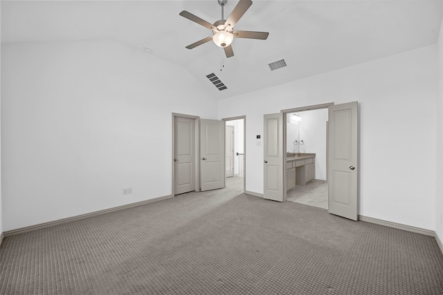 unfurnished bedroom featuring ceiling fan, light carpet, high vaulted ceiling, and ensuite bathroom