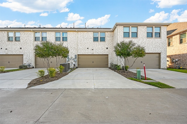 view of property featuring a garage and central AC unit