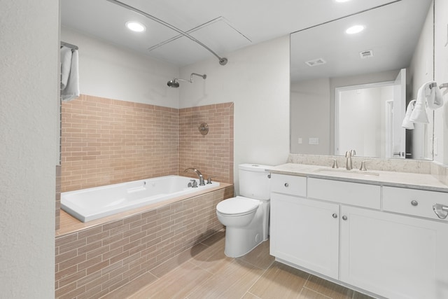 full bathroom with tiled shower / bath, vanity, and toilet