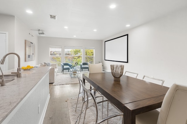 dining space featuring sink and wood-type flooring