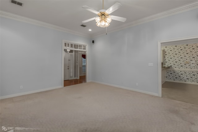 carpeted spare room featuring crown molding and ceiling fan