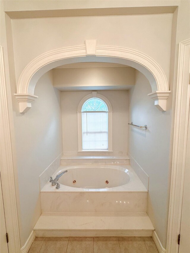 bathroom with crown molding, tile patterned floors, and a washtub