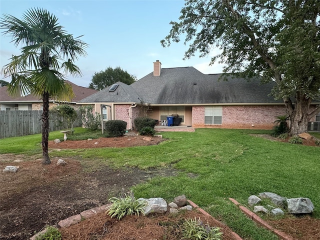 rear view of house featuring a lawn