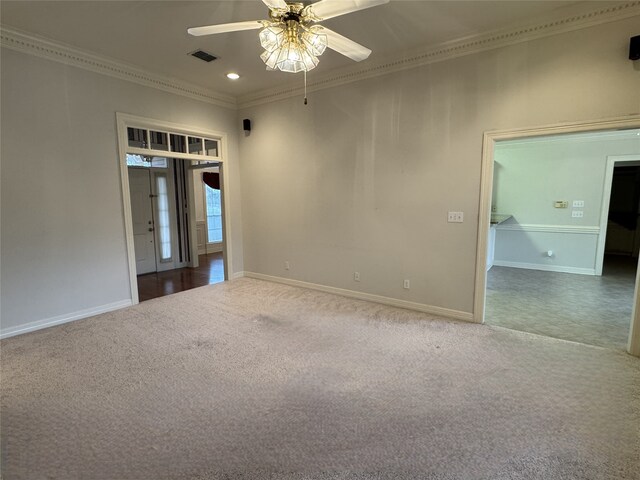 unfurnished living room featuring ornamental molding, a tiled fireplace, light colored carpet, and ceiling fan