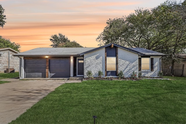 view of front of property featuring a lawn and a garage