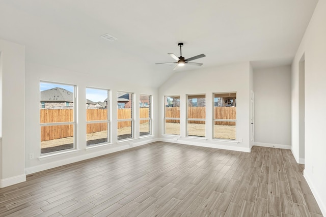 unfurnished sunroom featuring plenty of natural light, ceiling fan, and vaulted ceiling