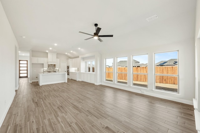 unfurnished living room featuring ceiling fan, a healthy amount of sunlight, and light hardwood / wood-style flooring