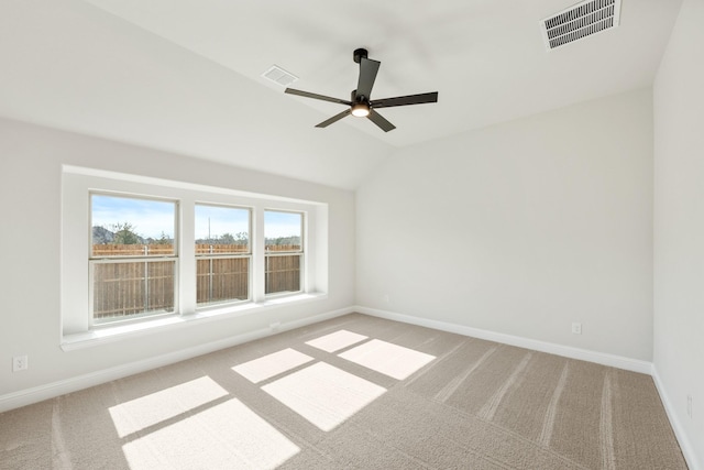 carpeted spare room featuring lofted ceiling and ceiling fan