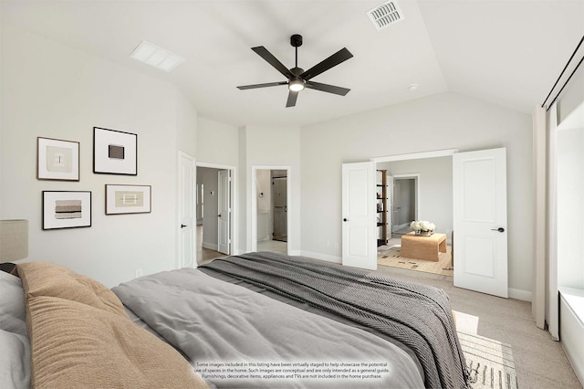 bedroom featuring lofted ceiling, ensuite bath, light colored carpet, and ceiling fan