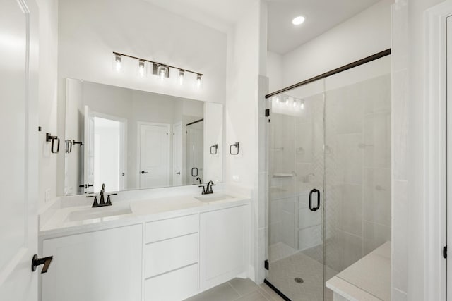 bathroom with walk in shower, vanity, and tile patterned flooring