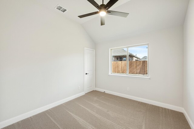 carpeted spare room with ceiling fan and vaulted ceiling