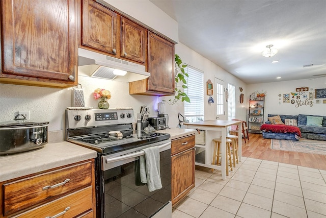 kitchen featuring stainless steel electric range oven and light tile patterned flooring