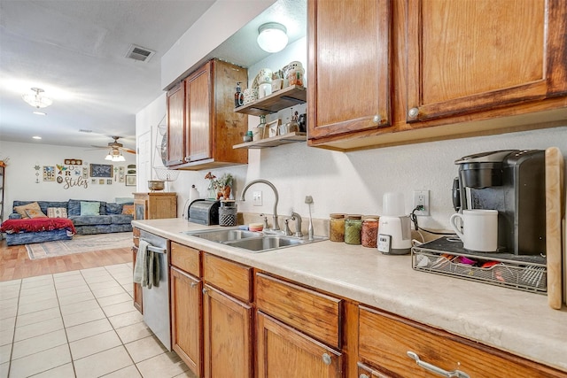 kitchen with stainless steel dishwasher, ceiling fan, light tile patterned floors, and sink