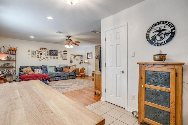 tiled living room featuring ceiling fan