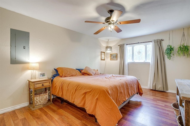 bedroom featuring electric panel, ceiling fan, and hardwood / wood-style floors