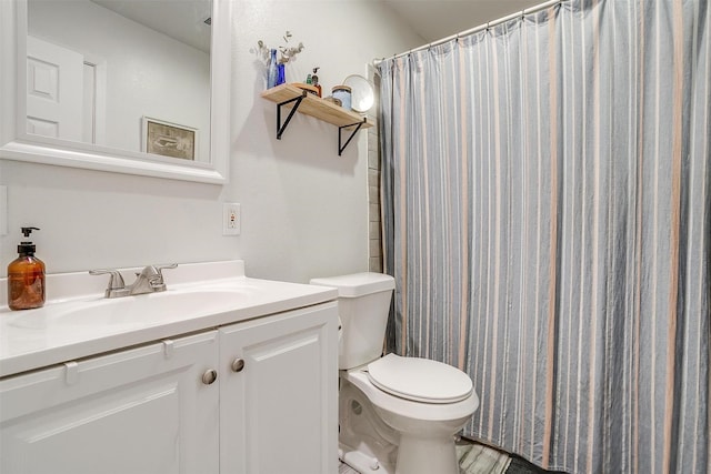 bathroom featuring a shower with shower curtain, vanity, and toilet