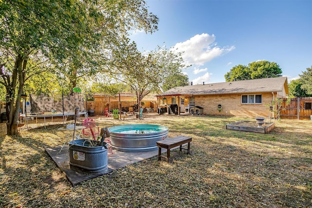 view of yard featuring a pool and a trampoline