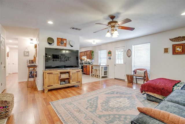 living room with ceiling fan and light hardwood / wood-style floors