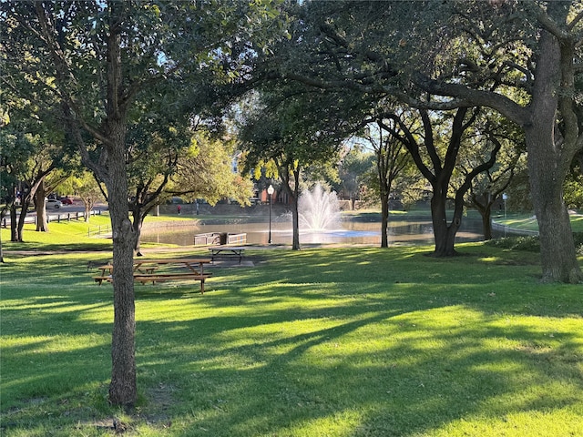 view of community featuring a lawn and a water view