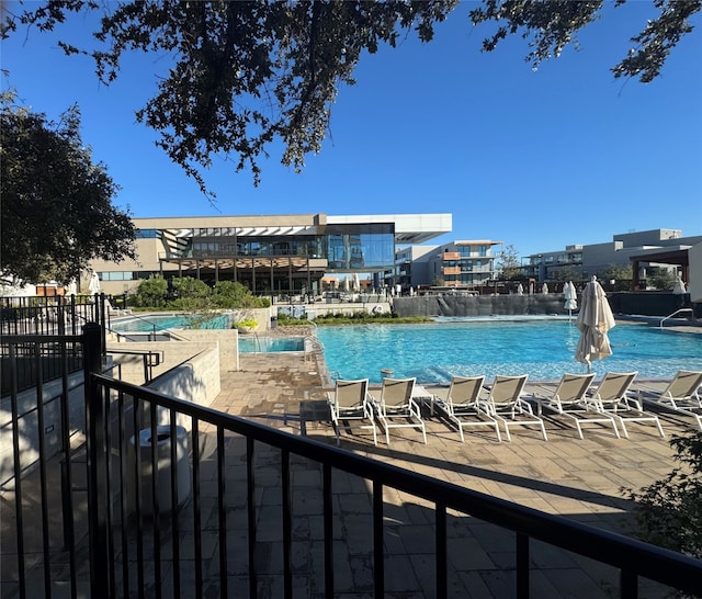 view of swimming pool featuring a hot tub and a patio area