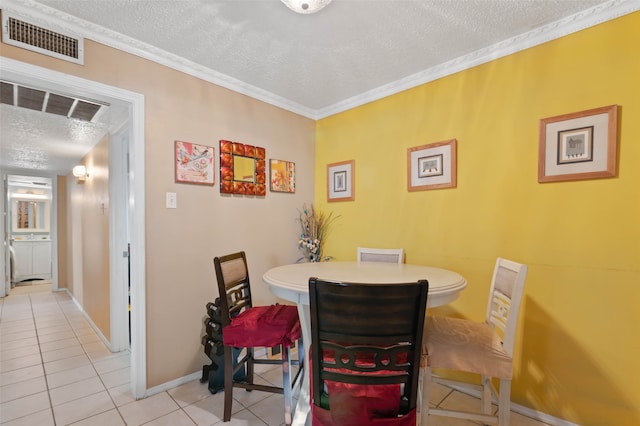 tiled dining room with a textured ceiling and crown molding