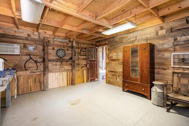 interior space with concrete floors, a wall mounted AC, and wood walls