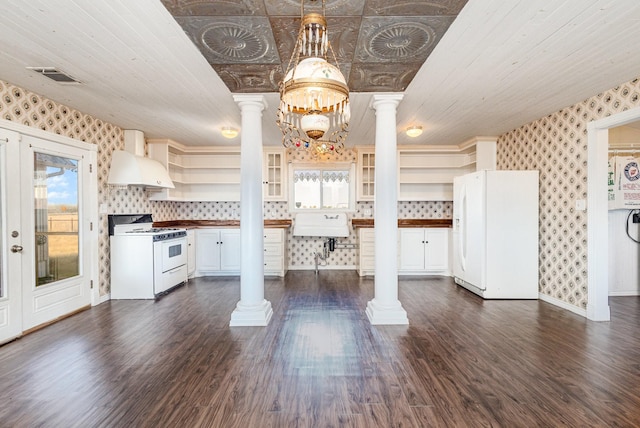 kitchen with ornate columns, hanging light fixtures, dark hardwood / wood-style floors, white appliances, and custom range hood