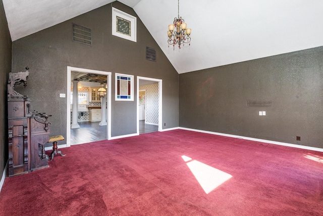 unfurnished bedroom with dark colored carpet, a notable chandelier, and high vaulted ceiling