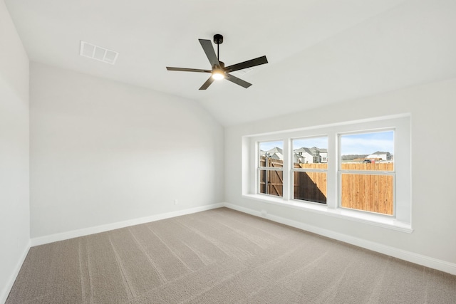 empty room featuring lofted ceiling, ceiling fan, and carpet