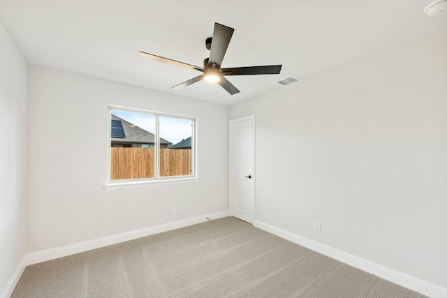 carpeted spare room featuring ceiling fan