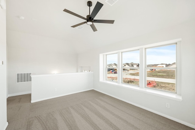 spare room with ceiling fan, light colored carpet, and a wealth of natural light