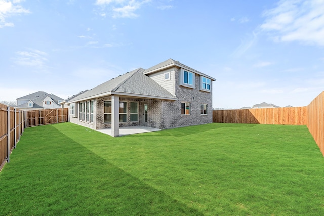 rear view of property featuring a yard and a patio area