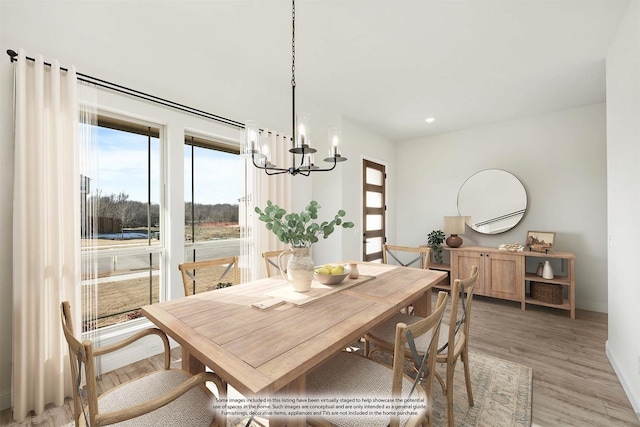 dining space with wood-type flooring and an inviting chandelier