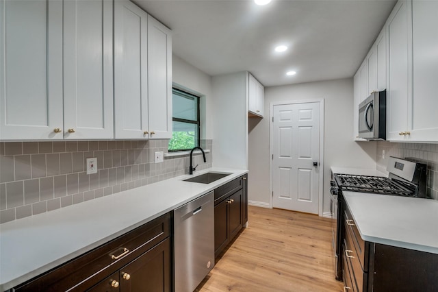 kitchen with white cabinetry, dark brown cabinets, and appliances with stainless steel finishes